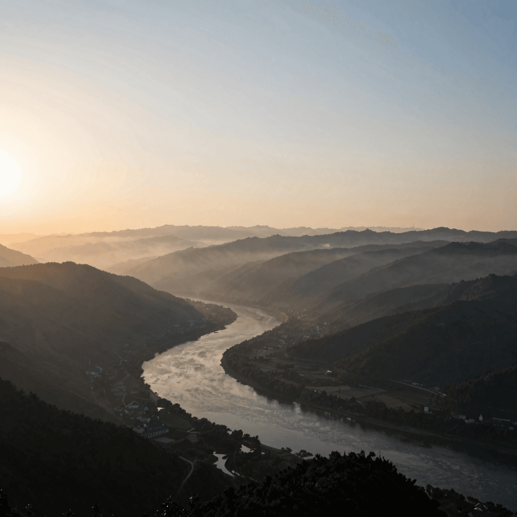 Wide natural landscape with mountains, river, and sunrise mist, cinematic composition, no text, no l